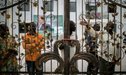Des militants du parti d'opposition congolais UPADS derrière les grilles cadenassées du siège de leur parti à Brazzaville, le 25 mars 2016