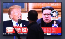 Un homme devant un écran de télévision montrant le président américain Donald Trump et le leader nord-coréen Kim Jong Un, à Séoul le 16 mai 2018