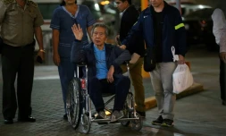 L'ancien président péruvien (1990-2000) Alberto Fujimori salue ses supporteurs alors qu'il est escorté hors de la clinique Centenario par son fils, le député Kenji Fujimori, à Lima, le 04 janvier 2018