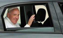 Assis à l'arrière de la Fiat, le pape François salue à son arrivée à Andrews Air Force Base aux Etats-Unis le 22 septembre 2015 