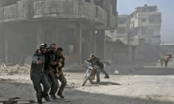 Des secouristes des Casques blancs aident un homme après un bombardement sur la ville de Hammouriyé, dans la Ghouta orientale, le 6 mars 2018