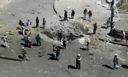 Des habitants autour d'un cratère provoqué par une frappe aérienne de la coalition arabe, le 1er octobre 2015 à Sanaa, au Yémen