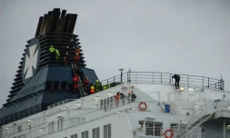 Des secouristes du Grimp (groupement de reconnaissance et d'intervention en milieux périlleux) tentent de faire descendre des migrants réfugiés en haut de la cheminée d'un ferry à Calais, le 3 mars 2019 
