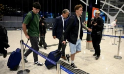 Les rugbymen français Hugo Auradou (g) et Oscar Jegou (2e à d) et leur avocat Rafael Cuneo Libarona (c), marchent avant de prendre un vol pour la France à l'aéroport d'Ezeiza, dans la province de Buenos Aires, en Argentine, le 3 septembre 2024