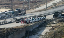 Véhicules de la Croix Rouge internationale et du Croissant Rouge Syrien à un point de passage le 18 décembre 2016 à Ramoussa dans la banlieue sud d'Alep