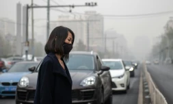 Une femme se protège de la pollution avec un masque à Pékin, en novembre 2018
