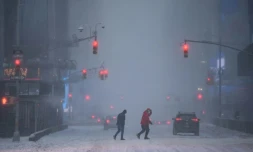 Des passants dans un Times Square sous la neige, à New York, le 29 janvier 2022
