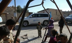 Des enfants dans les rues de la ville d'Utaya, dans l'enclave syrienne de la Ghouta Orientale, tandis qu'un convoi d'aide humanitaire pénètre dans la ville le 14 février 2018