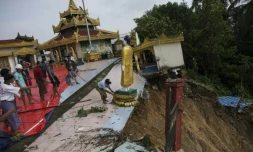 Des ouvriers déplacent une statue de Bouddha de la pagode Kyeik Than Lan, dans le sud de la Birmanie, endommagée par un glissement de terrain, le 18 juin 2018