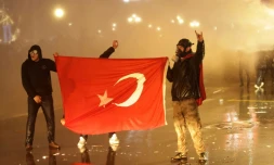 Des manifestants tiennent le drapeau turc lors de heurts avec la police, le 23mars 2025 à Ankara