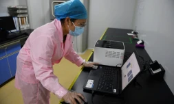 Une technicienne vérifie les résultats d'un test en utilisant le Flash 20, une machine conçue par l'entreprise chinoise de biotechnologie Coyote pour réaliser des
dépistages rapides au nouveau coronavirus, le 27 septembre 2020 à Pékin
