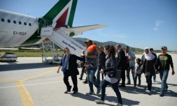 Des familles de réfugiés syriens embarquent à bord de l'avion du pape le 16 avril 2016 à l'aéroport de Mytilène