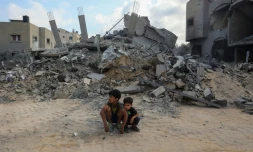Des enfants sont assis devant une montagne de gravats après un bombardement à Nousseirat, dans le centre de la bande de Gaza, le 12 août 2024
