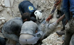 Des Syriens sauveteurs volontaires dénommés Casques blancs récupÚrent des blessés et des morts aprÚs des bombardements aériens sur un quartier nord de Alep, le 4 octobre 2016