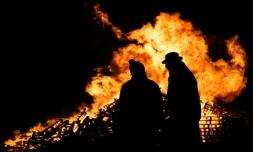 Deux agriculteurs devant un feu allumé lors d'un rassemblement contre la signature d'un accord de libre-échange entre l'Union européenne et des pays du Mercosur, à Dijon le 18 novembre 2024