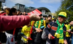 Un syndicaliste distribue des "cartons rouges à la retraite à 64 ans" à la sortie du métro à Saint-Denis, près de Paris, le 29 avril 2023 