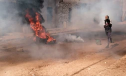 Un manifestant se protÚge le visage contre les gaz lacrymogÚnes lors de heurts avec la police, le 9 février 2024 à Dakar, au Sénégal