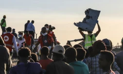 Un homme porte un débris d'avion sur le site du crash du Boeing 787 d'Ethiopian Airlines, près de Bishoftu, à 60 km d'Addis Abeba, le 10 mars 2019