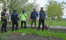 Un Ukrainien désigne à des enquêteurs la fosse où trois civils ont été enterrés dans le village de Stepanky, près de Kharkiv, le 11 mai 2022