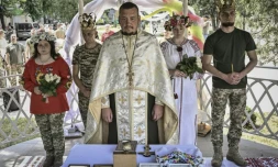 Des couples de militaires ukrainiens, Kristina et Vitali Orlich (à droite), ainsi que Kristina Liouta et Volodymyr Mikhalchouk (à gauche), pendant leur cérémonie de mariage dans la ville de Droujkivka, dans l'est de l'Ukraine, le 12 juin 2022