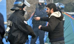 Un migrant face à un policier, le 29 février 2016 lors des opérations de démantÚlement dans le camp de la "jungle" à Calais