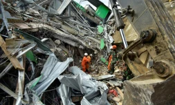 Des secours indonésiens sur le site d'un bâtiment effondré à Mamuju, le 16 janvier 2021, après un séisme de magnitude 6,2 qui a frappé l'île de Célèbres
