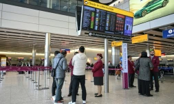 Des passagers devant le comptoir d'enregistrement fermé de la compagnie aérienne Qatar Airways, le 1er mars 2026 à l'aéroport Heathrow de Londres 