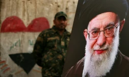 Un membre des Forces de mobilisation populaire irakiennes se tient derriĂšre un portrait du guide suprĂȘme iranien dĂ©funt Ali Khamenei, Ă la veille de son cortĂšge funĂšre, au mausolĂ©e de l'imam Hussein Ă Karbala, en Irak, le 7 juillet 2026