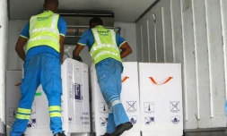 Des employés de l'aéroport déchargent des doses de vaccins contre le Covid-19 fournies par le dispositif Covax, le 24 février 2021 à Accra, au Ghana