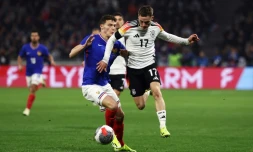 Le défenseur de la France Benjamin Pavard (à gauche) à la lutte avec le milieu de l'Allemagne Florian Wirtz (à droite) lors de la victoire de l'Allemagne contre la France au Groupama Stadium de Decines-Charpieu, prÚs de Lyon, le 23 mars 2024