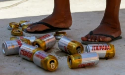 Shirlei Aparecida de Souza piétine des canettes vides ramassées dans les ruelles d'un quartier pauvre de Sao Paulo, le 29 juin 2023 au Brésil