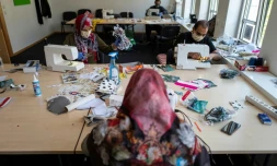 Des migrants d'Afghanistan cousent des masques de protection dans un centre communautaire, le 23 avril 2020 Ă Berlin, en Allemagne