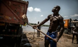 Des ouvriers congolais emplissent de sable des bennes, sur la berge de la rivière Congo, près de Brazzaville le 28 mars 2016