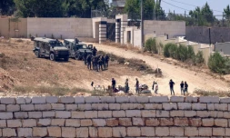 Des soldats israéliens au dessus de colons à Des soldats israéliens (en haut) montent la garde aux côtés de colons devant des maisons palestiniennes dans le village de Qusra, au sud de Naplouse, en Cisjordanie occupée, le 12 août 2026