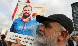 Un manifestant brandit le portrait d'une victime de la catastrophique explosion qui a ravagé le port de Beyrouth en 2020, lors d'une manifestation de commémoration et pour réclamer la punition des responsables, à Beyrouth, le 4 août 2025
