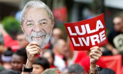Un partisan de Lula brandit un masque représentant le visage de l'ancien président brésilien et une pancarte "Lula libre" au lendemain de sa libération, lors d'un rassemblement devant le siÚge des métallos de Sao Bernardo do Campo, prÚs de Sao Paulo, le 9 novembre 2019