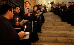 Des moines franciscains chantent au cours d'une procession dans l'église du Saint Sépulcre à Jérusalem, le 17 février 2018
