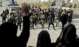 Des membres des forces spéciales irakiennes accueillis par la population dans un quartier de Mossoul repris aux jihadistes, le 27 novembre 2016 en Irak