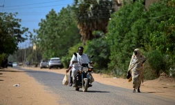 Un bénévole soudanais chargé de livrer des médicaments à domicile roule en moto à Khartoum, le 18 avril 2026