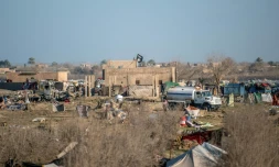 Le drapeau noir de l'organisation Etat islamique (EI) flotte au dessus d'un bâtiement dans la dernière poche de l'EI dans le village de Baghouz en Syrie, le 9 mars 2019