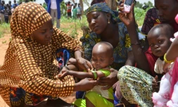 Au Niger, les mères utilisent un périmètre brachial (PB), un brassard tricolore, qui sert à mesurer l'épaisseur du bras et détecter la malnutrition, dans le village de Barago (sud), le 14 juillet 2016 