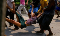 Transport d'un blessé lors des affrontements entre forces de l'ordre et manifestants dans la commune de Hlaing Tharyar, dans l'agglomération de Rangoun, le 14 mars 2021