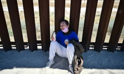 Une migrante chinoise, épuisée par la chaleur, se repose sur le mur frontalier après être entrée à pied aux États-Unis à Jacumba Hot Springs (Californie), le 5 juin 2024