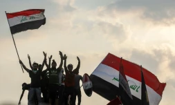 Des Irakiens agitent le drapeau national lors de manifestations dans le centre-ville de Bagdad, le 29 octobre 2019