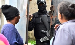 Des parents de détenus demandent des nouvelles de leurs proches à un policier devant la prison de Tela après des affrontements meurtriers, le 21 décembre 2019