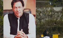 Un homme passe à vélo devant un portrait géant du Premier ministre pakistanais Imran Khan, le 19 février 2019 à Islamabad