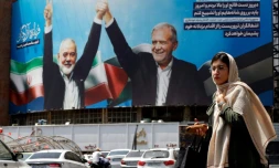 Une femme passe devant un panneau d'affichage représentant le président iranien Massoud Pezeshkian (à droite) et le chef du Hamas palestinien Ismaïl Haniyeh sur une place à Téhéran, le 8 août 2024