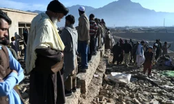 Des habitants rassemblés autour d'habitations endommagées après des bombardements, en périphérie de Kaboul, le 13 mars 2026 en Afghanistan