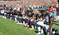 Des joueurs des New England Patriots, agenouillés au bord du terrain quelques heures après que Donald Trump a proposé de boycotter les équipes dont les joueurs "manquent de respect" à l'Amérique, le 24 septembre 2017 à Foxboro