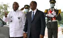 Le président ivoirien Alassane Ouattara (c) et son prédécesseur Laurent Gbagbo (g), à Abidjan, le 27 juillet 2021